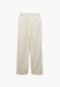 Beige bukser med elastisk talje, lige ben-design og to baglommer. Glat tekstur i en lys, neutral farve.