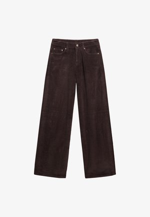 Brązowe sztruksowe spodnie o szerokich nogawkach z pionowymi prążkami, dwoma przednimi kieszeniami, zapięciem na guzik i metalowymi detalami. Miękka tekstura.