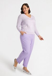 Lila V-Ausschnitt-Pullover mit strukturiertem Blumenmuster, kombiniert mit passenden lila Hosen und silbernen spitzen Absätzen. Hosen mit Taschen.
