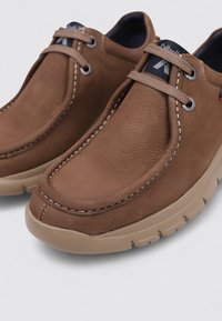 Chaussures en cuir marron avec une texture lisse, bout rond, couture contrastante, design à lacets et semelle en caoutchouc de couleur claire.
