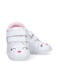 Zapatos blancos para bebés con acentos rosas, que cuentan con dos correas de Velcro ajustables, bordado de una cara juguetona y una suela de goma texturizada.