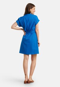 Korte mouw blauw shirtjurk met een ceintuur in de taille, kraag en een zoomlijn boven de knie. Gladde textuur en effen kleurontwerp.