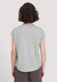 Lichtgrijze t-shirt met korte mouwen, opgerolde mouwen, ronde halslijn en afgeronde zoom. Soepele textuur en casual pasvorm.