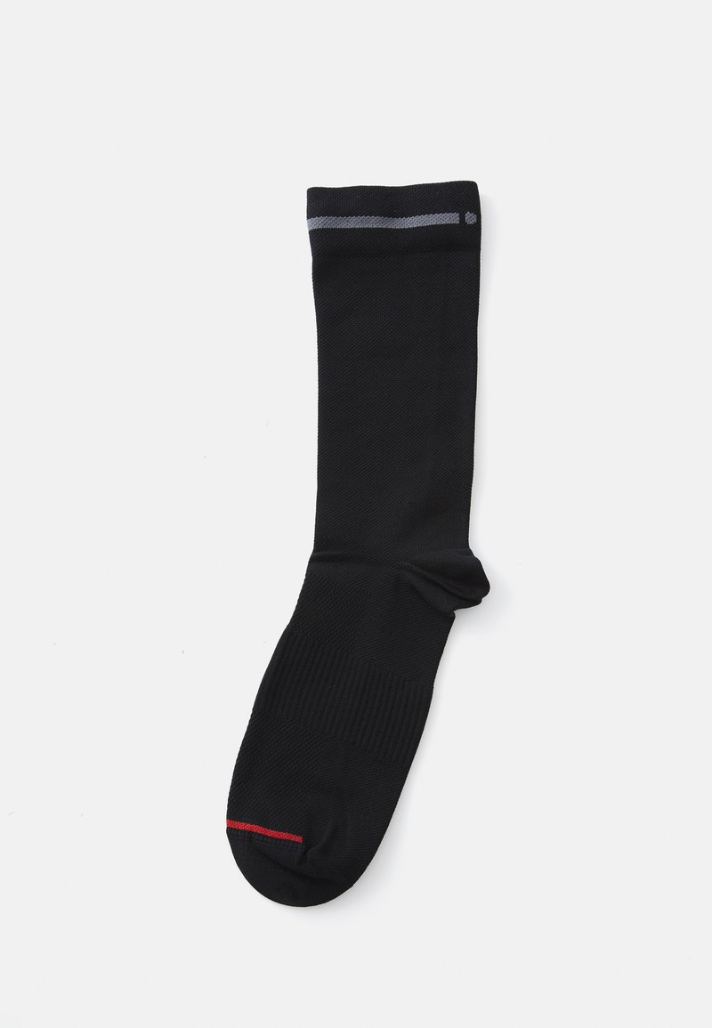Calcetín negro con puño acanalado, que presenta una delgada raya gris en la parte superior y un pequeño acento rojo cerca del dedo del pie. Textura suave y diseño de longitud hasta la rodilla.