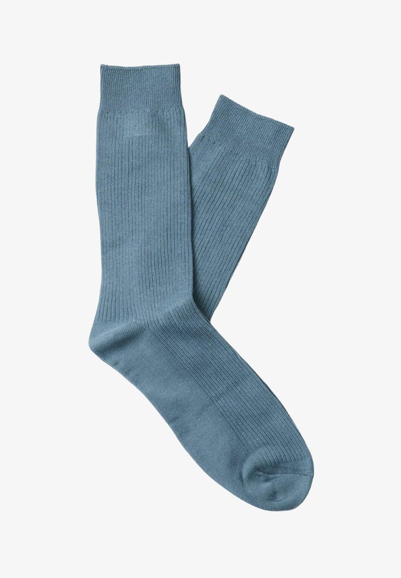 Paire de chaussettes bleues unies côtelées mi-mollet, en tissu tricoté doux, posées à plat avec une chaussette légèrement chevauchante l'autre.