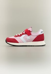 Ροζ και κόκκινο χαμηλό αθλητικό παπούτσι με λευκό λογότυπο αστεριού, λουράκι με βέλκρο, λευκά κορδόνια και μαύρη σόλα, απεικονισμένο σε πλευρική όψη σε ουδέτερο φόντο.