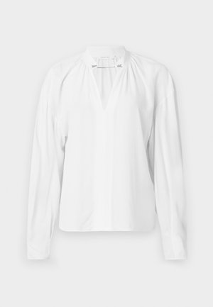 Blusa branca de mangas longas com decote em V, detalhes franzidos na gola e um tecido liso e leve. Design simples e minimalista.