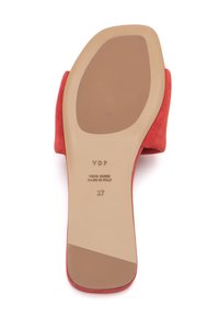 Scarpa in suede rosso con una suola in gomma beige liscia. Presenta un marchio impresso e indicazioni di taglia sulla soletta. Forma pulita e curvilinea.