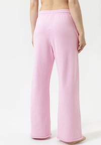 Roze sweatpants gemaakt van zachte stof, met een losse pasvorm, elastische tailleband en zonder zichtbare patronen of hardwaredetails.