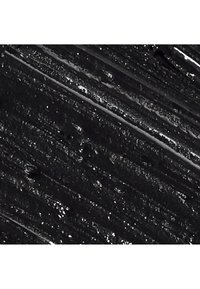 Superficie negra texturizada con franjas brillantes y mate, que presenta grosores variados y áreas sutilmente reflectantes, creando un efecto visual dinámico.