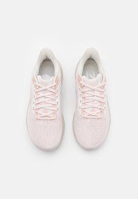 Helle rosa Sportschuhe mit einem atmungsaktiven Mesh-Obermaterial, strukturiertem Oberflächen, weißen Schnürsenkeln und einer gepolsterten Sohle. Verfügt über minimale Designakzente.