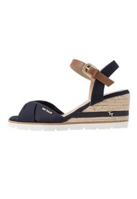 Navy plátěné klínové sandály s hnědým popruhem kolem kotníku, jutovou střední podrážkou, bílou gumovou podešví a nařaseným detailem na špičce. Zlatý akcent s logem.