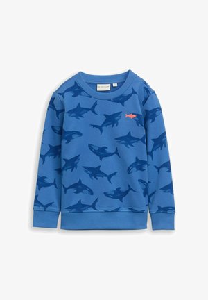 Niebieska bluza z wzorem rekina w ciemniejszym odcieniu niebieskiego, z pomarańczowym akcentem rekina na piersi. Ściągacze na mankietach i kołnierzu. Materiał bawełniany.