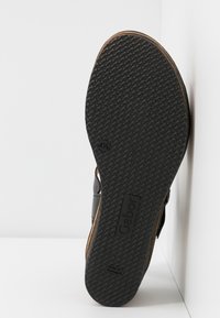 Semelle en caoutchouc noir avec motif texturé, bord beige, et logo "Gabor" embossé. Présente une forme incurvée et une surface lisse. Taille indiquée comme 41½.