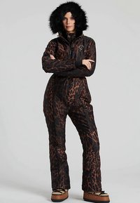Tuta intera con stampa leopardata in nero e marrone, con cappuccio foderato in pelliccia, zip frontale e silhouette aderente con gambe a zampa d'elefante.