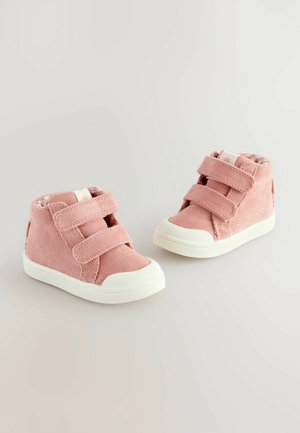 Lyserøde fløjl høje sko med to Velcro-stropper og hvide gummisåler. Har blød tekstur og et polstret indre for komfort.