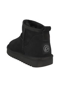 Botas negras hasta el tobillo con un interior suave y aterciopelado, exterior de ante liso, tirador y suela de goma texturizada. Presentan detalles de costura y parche con el logo.