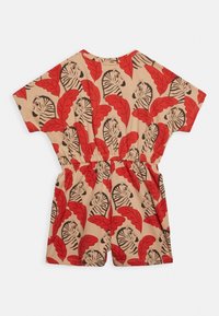 Beżowy kombinezon z krótkim rękawem w czerwony wzór liści i głów zebry; elastyczny pas; gładki, lekki materiał; luźny krój.