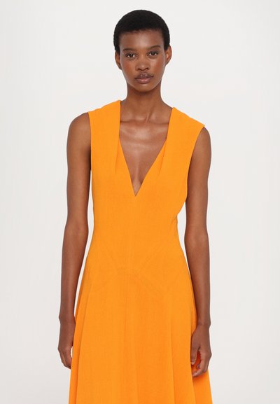 Orange sleeveless dress with a deep V-neck, textured fabric, and flared silhouette, featuring seam details for added dimension.