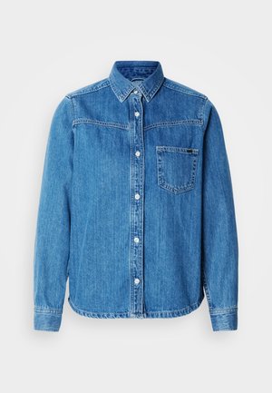 Blauw denim overhemd met knopen, een kraag, een voorzak en witte knopen. Heeft een licht gebogen zoom en lange mouwen.