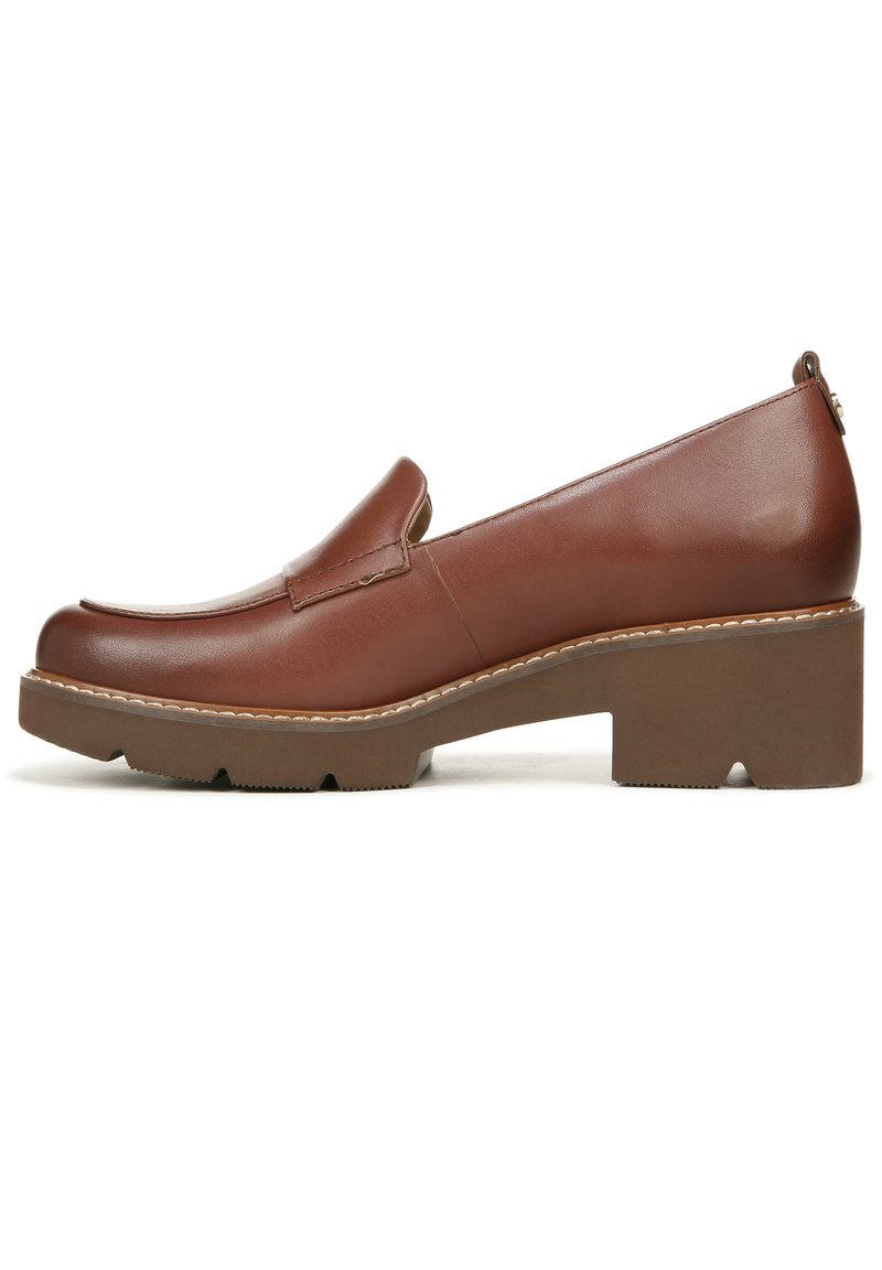 Bruine leren instapschoen met een rond neus, verhoogde blokhak en een gestructureerde zool. Voorzien van subtiele stiksels en een strak ontwerp.
