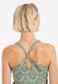 Baddräkt med ett grönt mönstrat tyg, öppen ryggdesign, justerbara stänger och en nyckelhål-detail vid nacken.