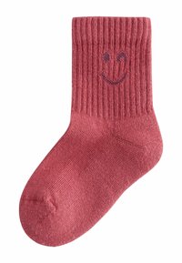 Puuvillasest segust sokk sügava roosa tooniga, millel on sooniline tekstuur ja lilla naerunägu mustrina ülaosas. Põlveni ulatuv disain.
