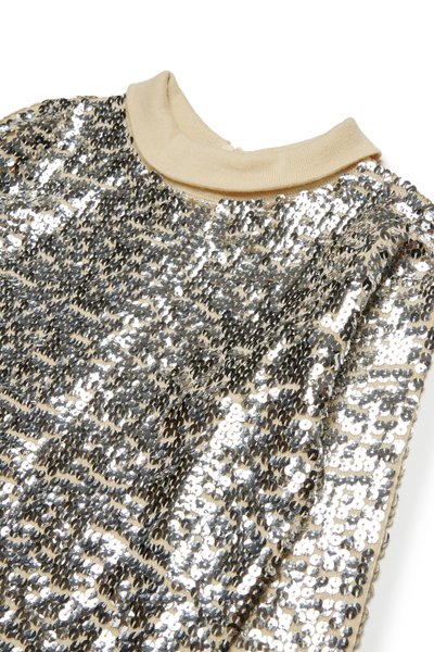 Top à sequins avec un col en ribbed beige. La surface est recouverte de sequins argentés disposés en motif ondulé, réfléchissant la lumière.