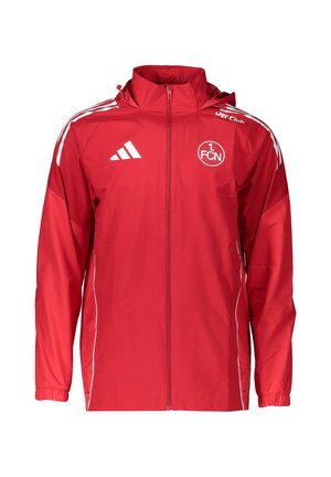 Czerwona sportowa kurtka z pełnym zamkiem, logo Adidas, emblemat klubu 1. FCN, białe paski na ramionach i elastyczne mankiety.