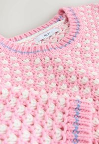 Pink knitted sweater with white and blue accents, featuring a textured pattern and a round neckline. Tag reads "NEXT."