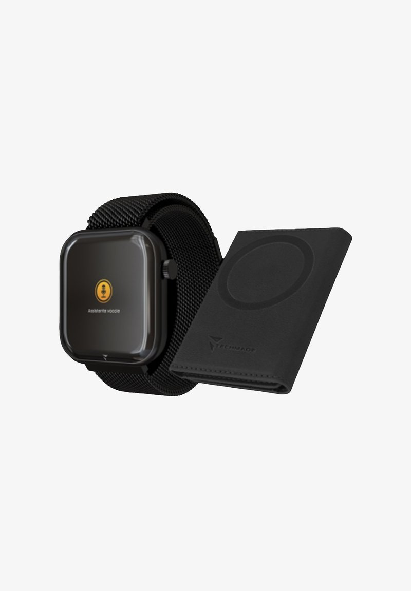 Orologio smartwatch nero con quadrante quadrato e cinturino a rete, accanto a un portafoglio in pelle nera con un pad di ricarica magnetico circolare.