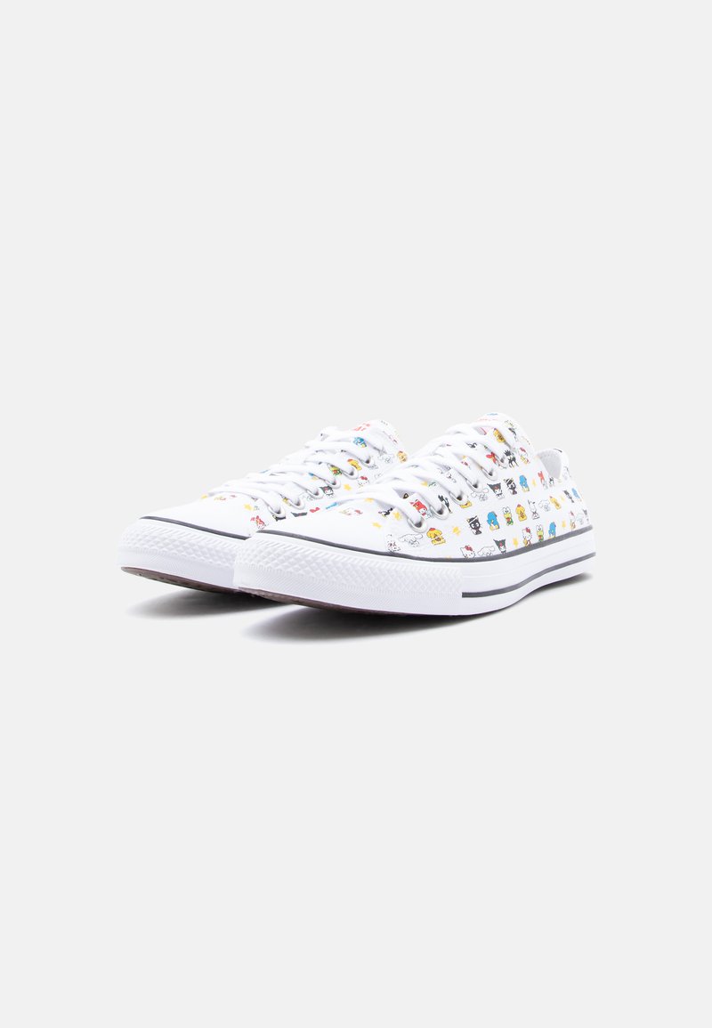 Sneakers basse bianche con lacci bianchi e stampe di piccoli personaggi dei cartoni animati colorati su tutto il tessuto, striscia nera sulla suola.