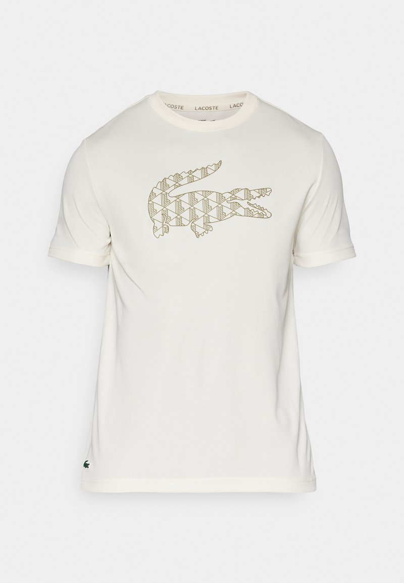 T-shirt blanc à manches courtes avec un motif texturé de logo crocodile en or à l'avant et un petit détail crocodile vert sur l'ourlet.