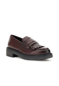 Mocasini din piele maro cu detalii din franjuri, vârf rotunjit și o talpă groasă neagră. Prezintă cusături pe margine și un toc ușor.
