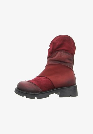 Red leather and suede ankle boot with a rounded toe, textured upper, and a chunky black heel. Features layered design and soft fabric accents.