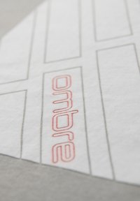Gros plan d'une pièce de patron en papier blanc avec des lignes noires et « ondre » imprimé en rouge dans une section.