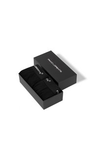 Czarne bawełniane skarpetki w prostokątnej czarnej pudełku z logo na elastycznej opasce. Pudełko ma minimalistyczny design z matowym wykończeniem.