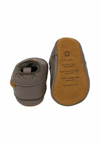 Scarpe per neonati in pelle marrone con suola in camoscio morbido, forma arrotondata, caviglia elastica per una facile vestibilità e dettagli cuciti sui lati.