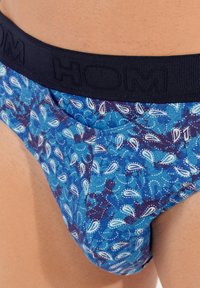 Blaue gemusterte Slips mit einem marineblauen Bund mit eingeprägtem Markenzeichen, aus weichem Stoff mit Paisleymuster und strukturierten Akzenten.