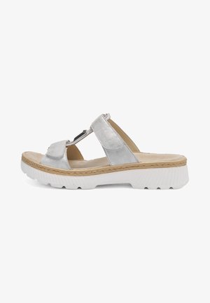 Zilveren sandaal met open tenen, twee verstelbare bandjes, gevoerde beige binnenzool, decoratieve metalen details en een dikke witte, gestructureerde zool.