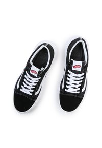 Tenisi negri și albi cu superior din suede și pânză, șireturi albe și etichetă cu logo-ul Vans. Au o talpă din cauciuc și cusături în contrast.