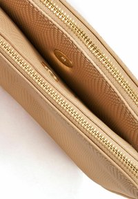 Beżowy portfel teksturowany ze złotymi zamkami, posiadający dwie przegrody i gładkie wykończenie, prezentujący subtelną, wzorzastą powierzchnię.