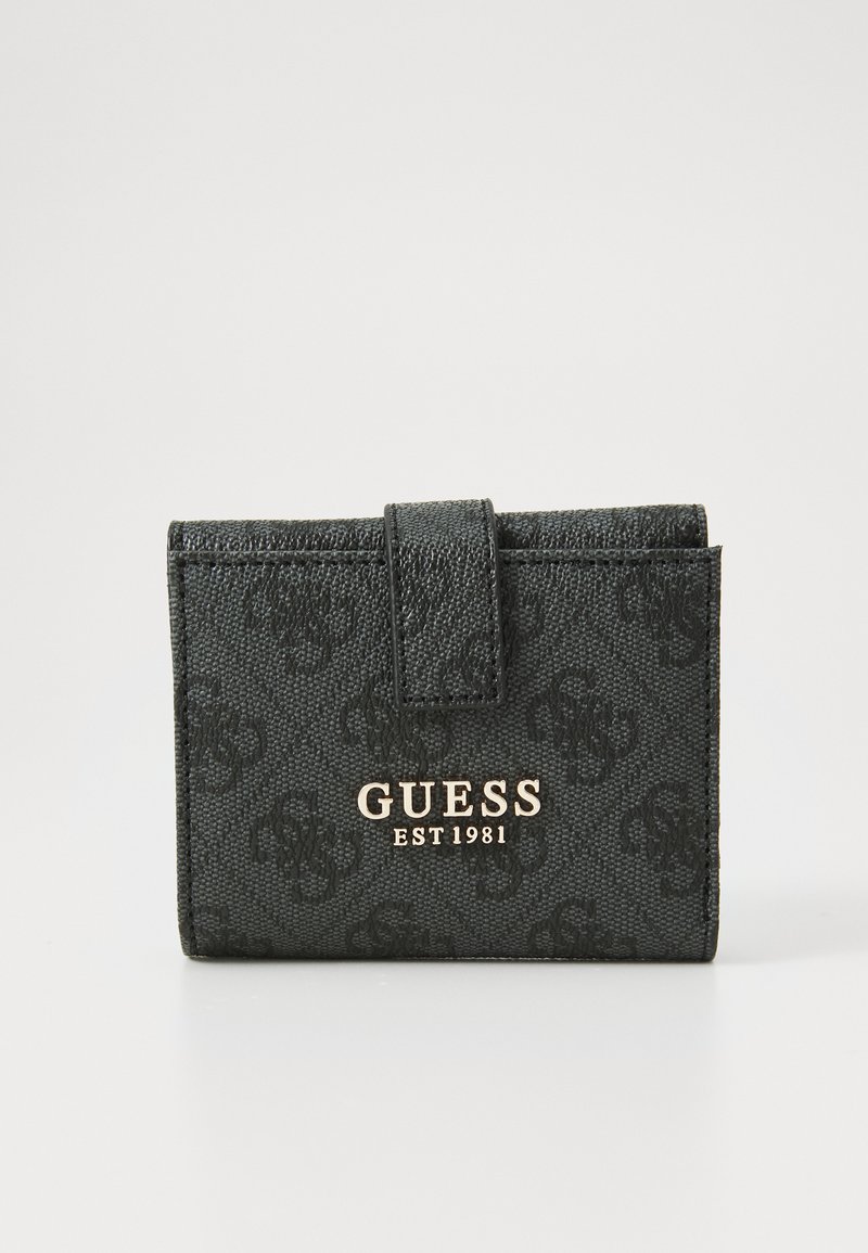 Portefeuille noir texturé avec motif de logo en relief, fermé par un système de rabat. Lettres dorées "GUESS EST 1981" accentuent l'avant.