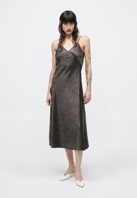 Satīna kleita tumši pelēkā krāsā ar piegulošu korseti, plānām lencītēm un vaļēju, potīšu garuma svārku. Ar smalku teksturētu apdari.