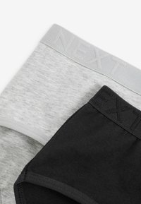 Two pairs of underwear, one grey with a textured waistband and logo, and one black with a smooth waistband and logo, stacked together.