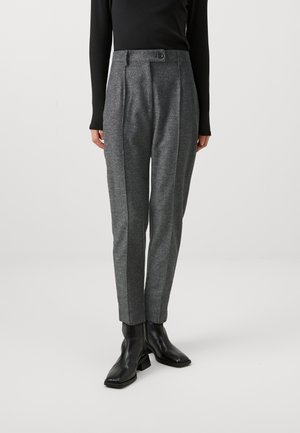 Pantalons gris sur mesure avec une finition texturée, dotés de plis marqués et d'une taille haute, assortis à des bottines noires.