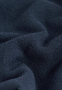 Marinblått, mjukt och texturerat tyg med lätt stretch, som har en slät yta. Inga mönster eller synlig hårdvara.