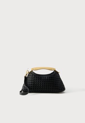 Black woven handbag with curved shape, gold-tone metal top handle, and detachable black shoulder strap on a white background.