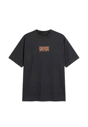 Czarny t-shirt z krótkim rękawem z pomarańczowym tekstem "HUMAN MOTION" oraz mniejszymi słowami "STRENGTH. BREATHE. GROUND. FLOW." umieszczonymi na środku klatki piersiowej.