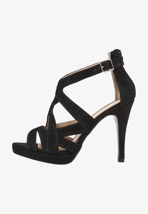 Schwarze Wildleder-Pumps mit hohen Absätzen, überkreuzten Riemen, einem Reißverschluss hinten und einer strukturierten Oberschicht. Die gestapelte Plateausohle sorgt für zusätzliche Höhe.